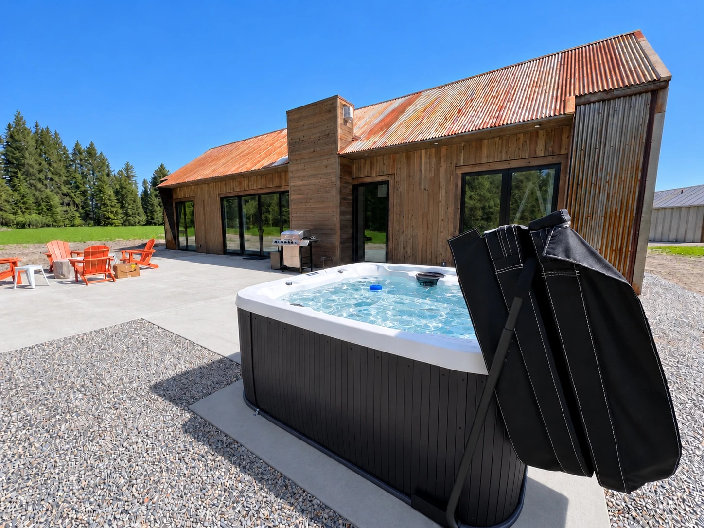 Outdoor hot tub beside a rustic Montana vacation home under a clear blue sky