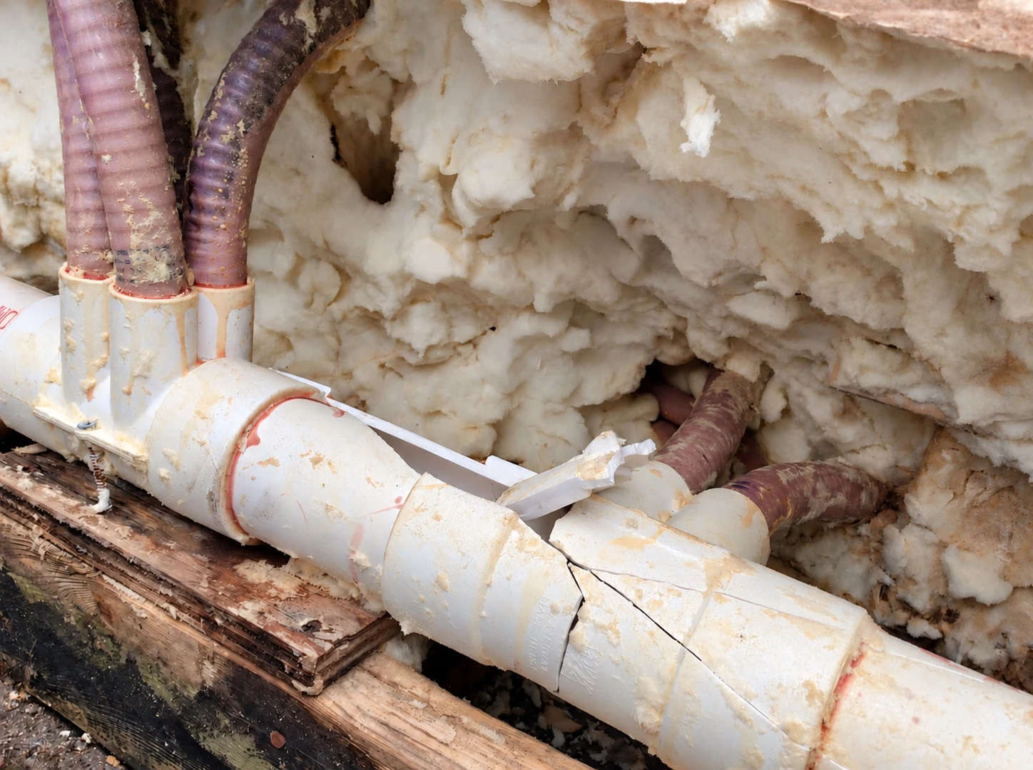 Close-up of cracked hot tub plumbing surrounded by insulation